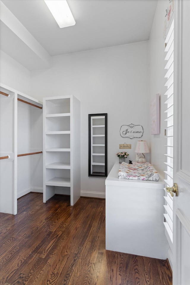 walk in closet with dark wood-type flooring