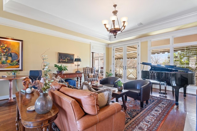 living room with french doors, wood finished floors, a wealth of natural light, and a notable chandelier