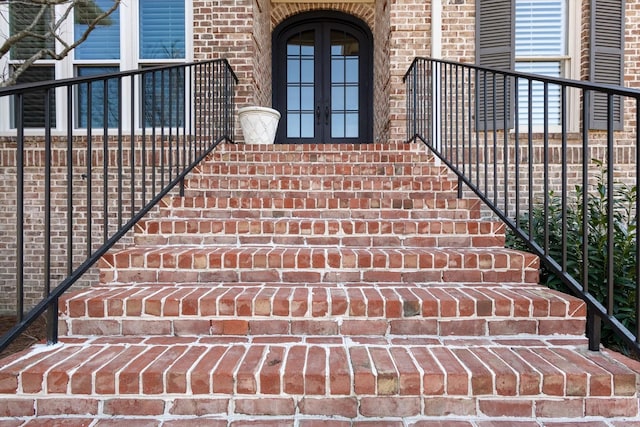 entrance to property featuring french doors and brick siding