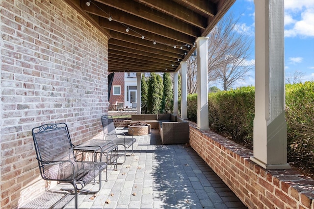 view of patio with an outdoor living space with a fire pit