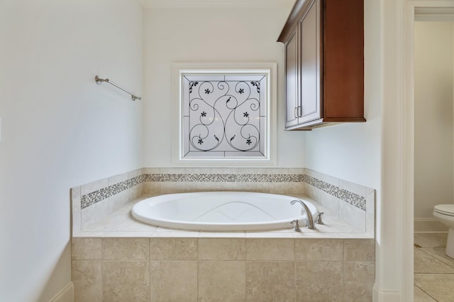 full bath with tile patterned flooring, a garden tub, and toilet