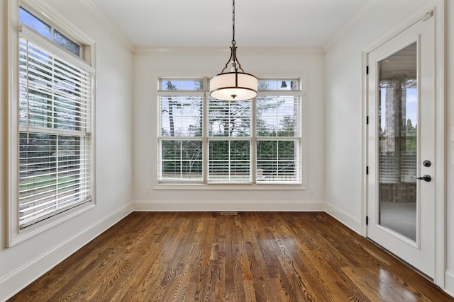 unfurnished dining area with dark wood-style flooring, plenty of natural light, and crown molding