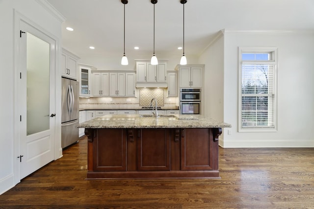 kitchen with dark wood-style floors, glass insert cabinets, appliances with stainless steel finishes, ornamental molding, and backsplash