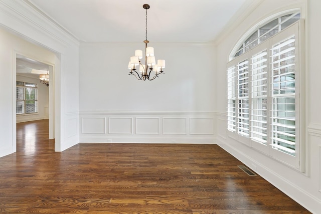 unfurnished dining area with an inviting chandelier, visible vents, and dark wood finished floors