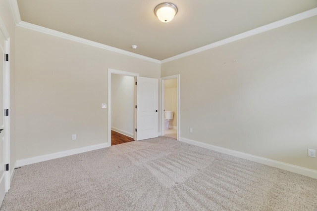 spare room with ornamental molding, carpet flooring, and baseboards