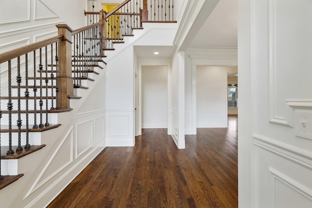 interior space with ornamental molding, wood finished floors, and a decorative wall