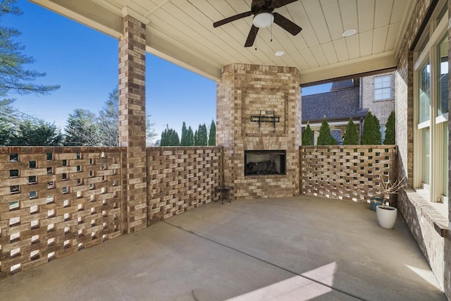 view of patio / terrace with an outdoor brick fireplace and a ceiling fan