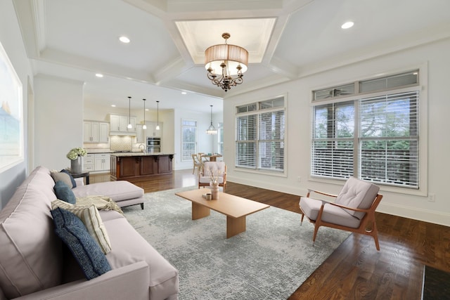 living area featuring coffered ceiling, baseboards, beam ceiling, dark wood finished floors, and an inviting chandelier