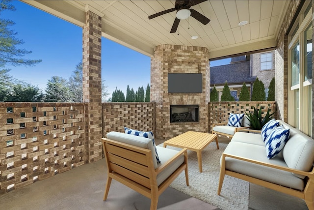 view of patio with ceiling fan and an outdoor living space with a fireplace