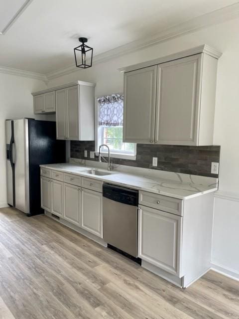 kitchen featuring stainless steel appliances, a sink, backsplash, and ornamental molding