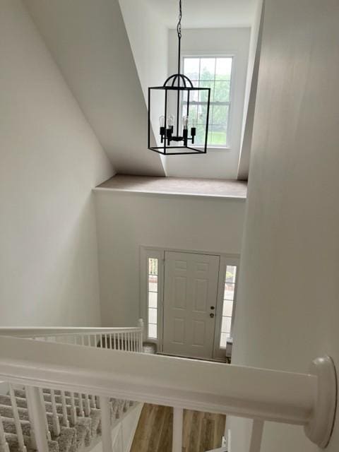 entryway with wood finished floors and an inviting chandelier