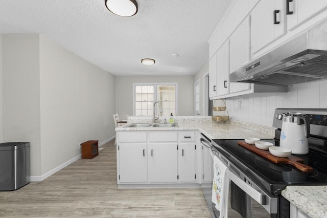 kitchen featuring light wood-style flooring, under cabinet range hood, a peninsula, a sink, and electric range oven