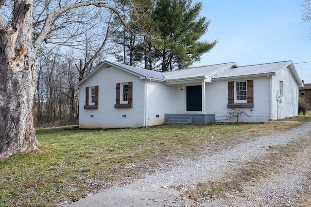 ranch-style home featuring brick siding, entry steps, crawl space, metal roof, and a front lawn