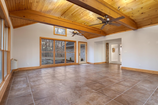 spare room featuring vaulted ceiling with beams, dark tile patterned flooring, and baseboards