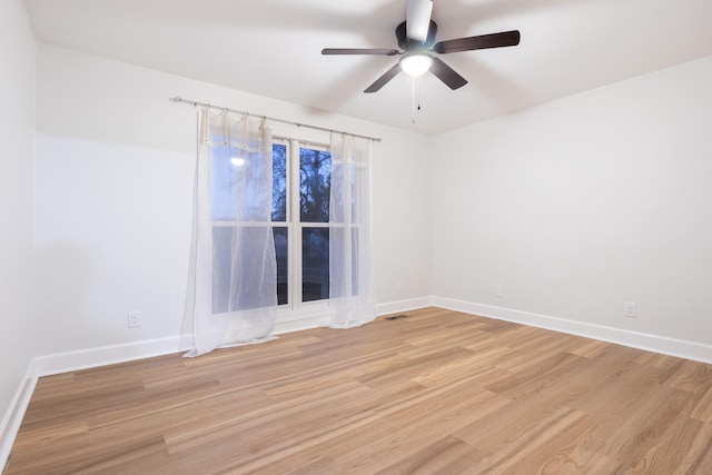 empty room featuring visible vents, ceiling fan, light wood-style flooring, and baseboards