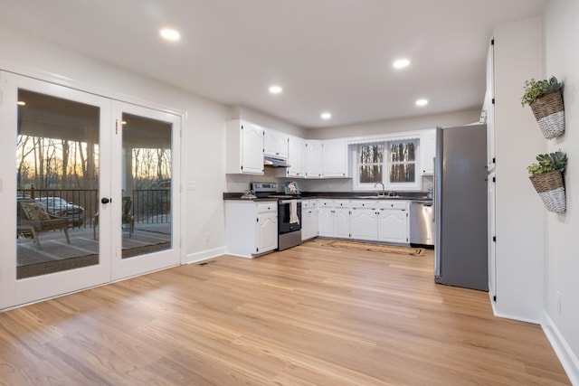 kitchen with light wood-style flooring, recessed lighting, under cabinet range hood, white cabinets, and appliances with stainless steel finishes