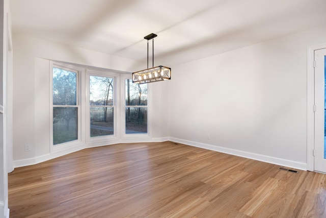 unfurnished dining area with baseboards, visible vents, and light wood-style floors