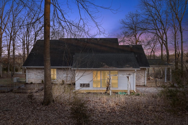 rear view of house with roof with shingles