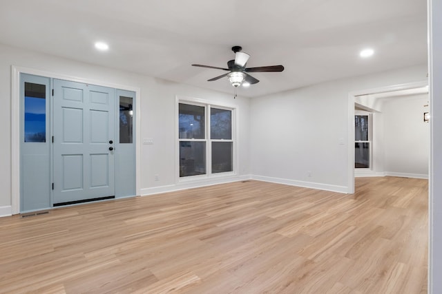 interior space featuring light wood finished floors, baseboards, and a ceiling fan