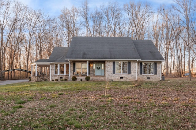 view of front of property featuring crawl space, brick siding, a shingled roof, and a front yard