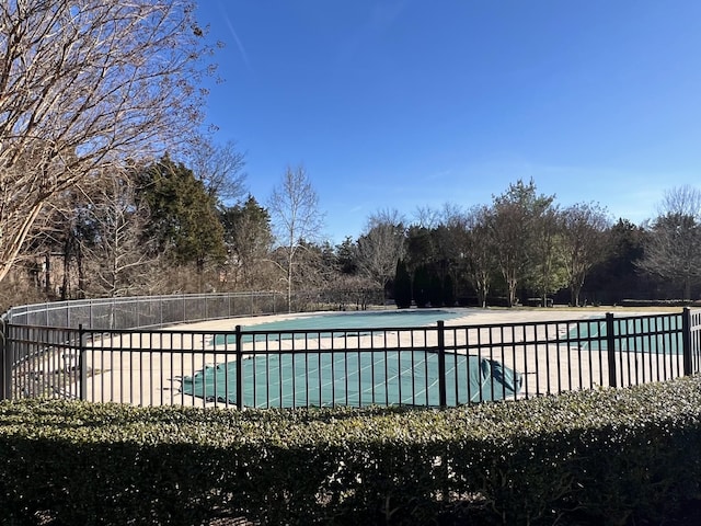 pool with a patio and fence