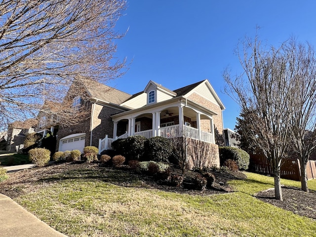 view of side of home featuring a garage, a porch, and a lawn