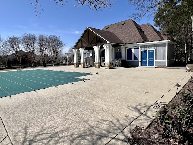 view of swimming pool with a covered pool, fence, and a patio