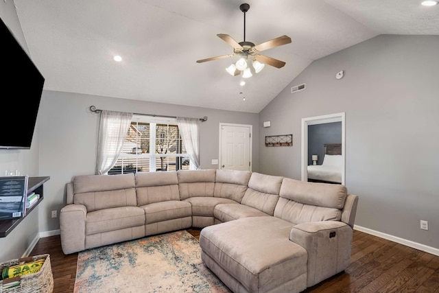 living room featuring lofted ceiling, visible vents, baseboards, and wood finished floors