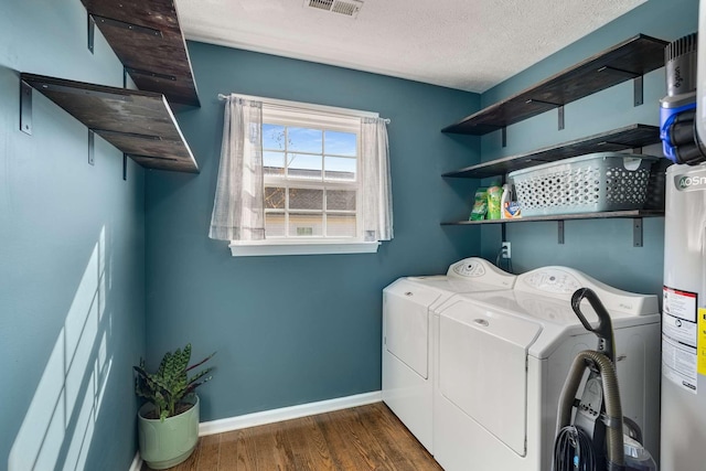 laundry room with dark wood-style floors, a textured ceiling, separate washer and dryer, laundry area, and baseboards