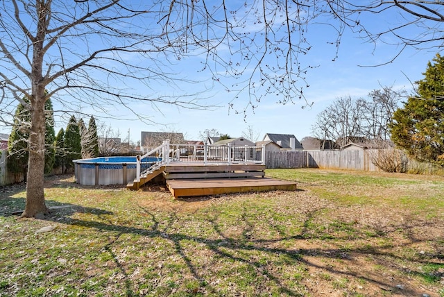 view of yard with a fenced backyard, a wooden deck, and an outdoor pool