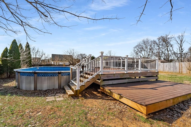 wooden deck featuring fence and an outdoor pool