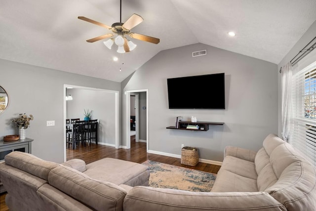 living room with visible vents, baseboards, a ceiling fan, dark wood-style flooring, and vaulted ceiling