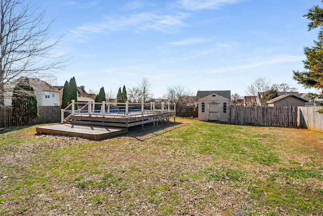 view of yard with a storage shed, a deck, an outdoor structure, and a fenced backyard