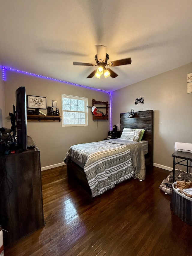 bedroom featuring a ceiling fan, baseboards, and wood finished floors