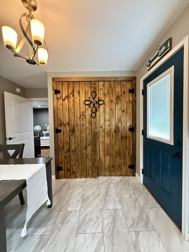 entrance foyer featuring marble finish floor and an inviting chandelier