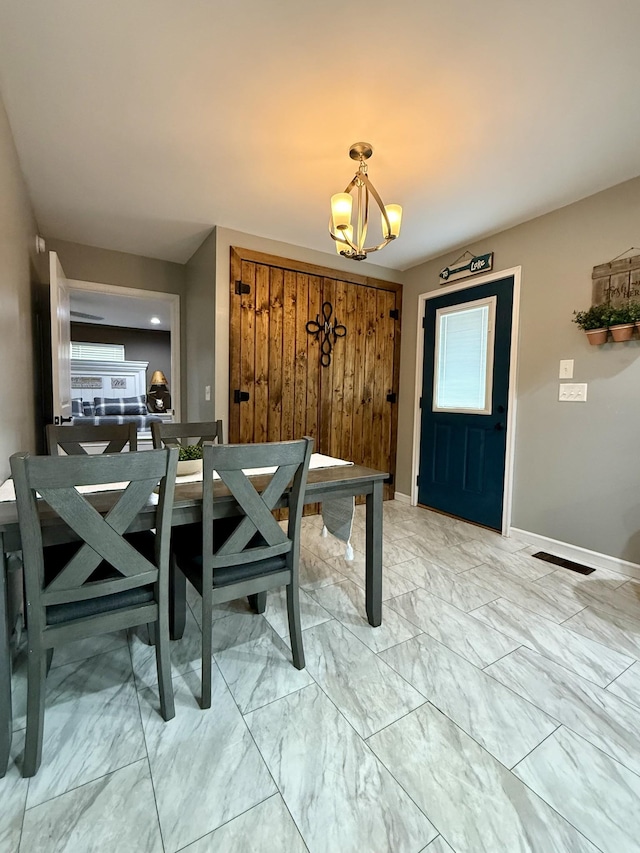 dining area featuring marble finish floor, baseboards, and a chandelier