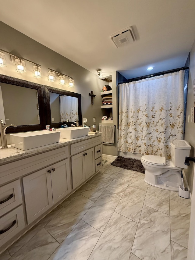 bathroom featuring toilet, a sink, visible vents, marble finish floor, and double vanity