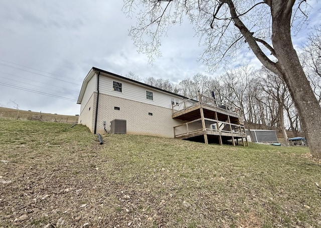 back of property with a yard, brick siding, and a wooden deck