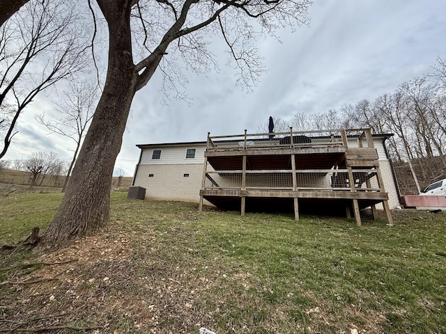 rear view of property with a yard and a wooden deck