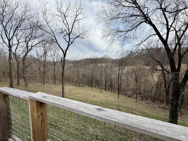 exterior space with fence and a forest view