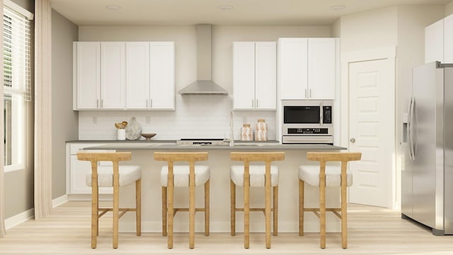 kitchen featuring stainless steel microwave, backsplash, refrigerator with ice dispenser, wall chimney range hood, and oven