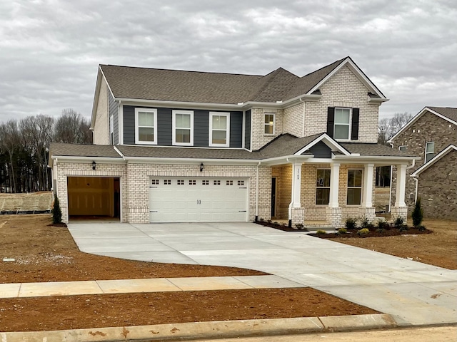 craftsman inspired home featuring concrete driveway, brick siding, an attached garage, and roof with shingles