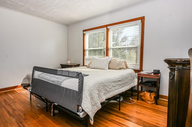 bedroom with baseboards and wood finished floors