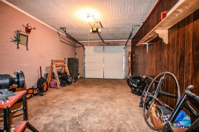 garage with concrete block wall and a garage door opener