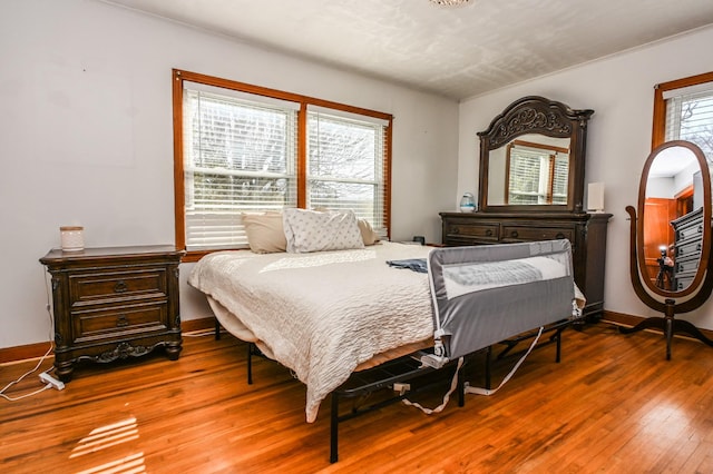 bedroom featuring baseboards and hardwood / wood-style floors