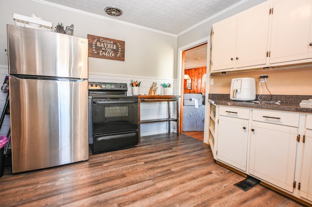 kitchen with a textured ceiling, electric range, wood finished floors, white cabinetry, and freestanding refrigerator