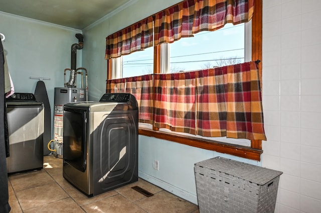 laundry room featuring tile patterned flooring, laundry area, water heater, washing machine and clothes dryer, and crown molding