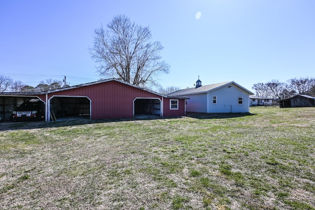 exterior space with a garage, a pole building, a front lawn, and an outdoor structure