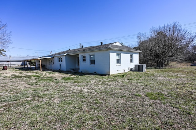 rear view of property featuring crawl space, brick siding, a yard, and central AC