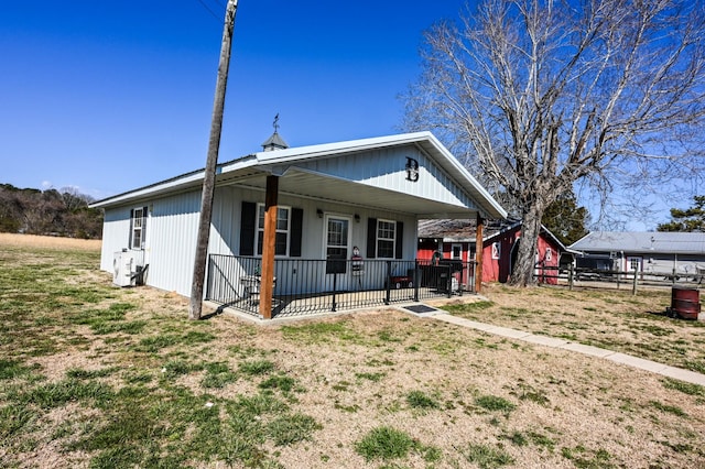 view of front of home featuring covered porch and fence